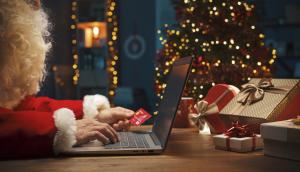 Santa character online shopping with credit card in hand