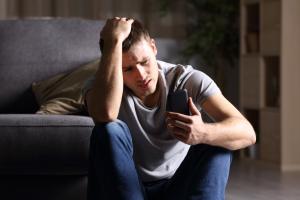 smishing txt Concerned man looking at sms message