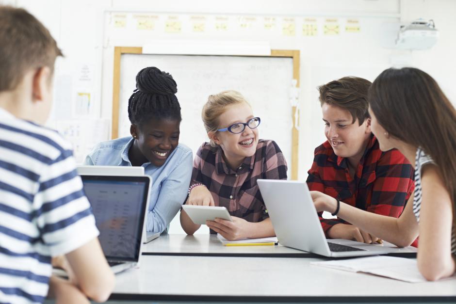 students in classroom working on laptops